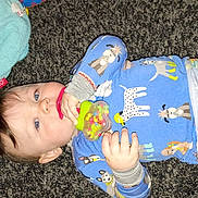 Christopher joined the competition — help win amazing prizes! baby, child, pajamas, carpet, toy, teether, blue_eyes, plush_toy, animal_print, lying_down, infant, cute, hand, face, clothing, floor, indoor, skin, person, young_child