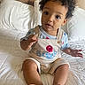 Princeton joined the competition — help win amazing prizes! toddler, child, baby, curly_hair, overalls, bed, white_bedspread, pillow, indoor, cute, expression, hands, feet, skin, clothing, person, sitting, young_child, portrait, exploring