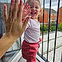 Elsa Stefania joined the competition — help win amazing prizes! toddler, child, smiling, high_five, hand, pink_pants, white_shirt, balcony, railing, outdoor, happy, person, window, glass, reflection, house, garden, daylight, playful, joy