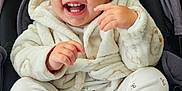 Elsa Stefania is registered to the contest to win money with this photo: toddler, child, smiling, laughing, hooded_jacket, white_clothing, socks, stroller, baby, cute, happy, indoor, cozy, playful, person, face, hands, foot, casual_wear, infant