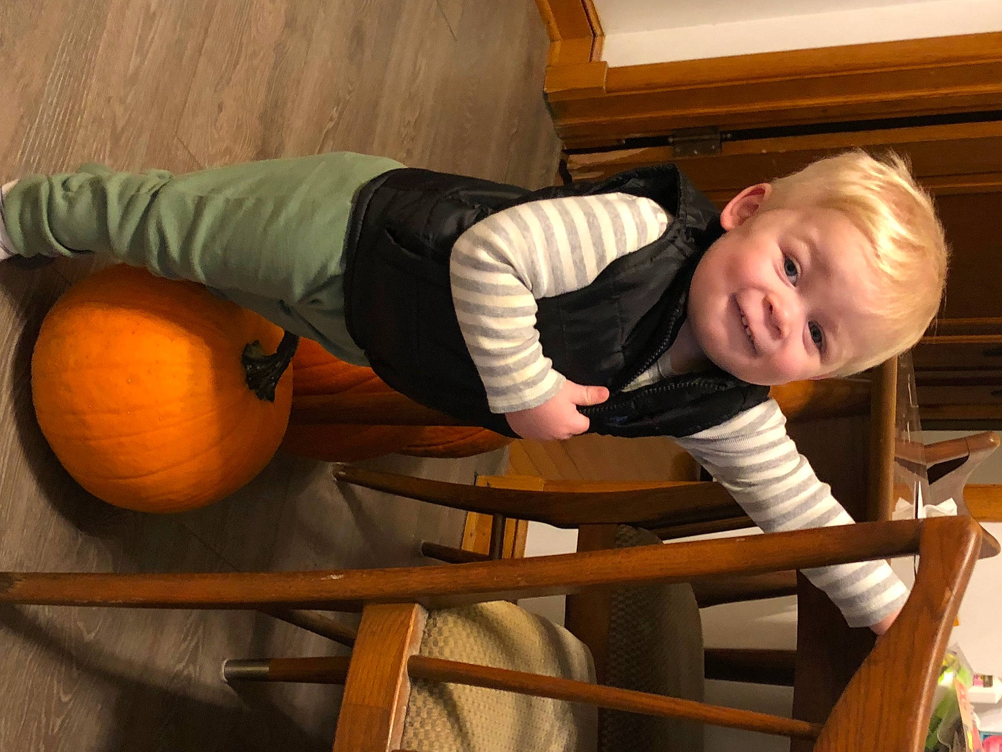 Damien is registered to the contest to win money with this photo: arm, baby_toddler_clothing, bitter_orange, calabaza, comfort, flooring, head, human_body, mandarin_orange, natural_foods, orange, organ, person, pumpkin, sleeve, smile, squash, toddler, valencia_orange, winter_squash