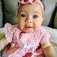 Luna is registered to the contest to win money with this photo: baby, child, pink_dress, headband, bow, blue_eyes, smiling, cute, portrait, infant, sitting, indoors, couch, clothing, face, person, happy, young_child, closeup, adorable