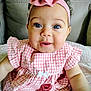 baby, child, pink_dress, headband, bow, blue_eyes, smiling, cute, portrait, infant, sitting, indoors, couch, clothing, face, person, happy, young_child, closeup, adorable