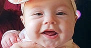 Raven is registered to the contest to win money with this photo: baby, bow, child, clothing, cute, family, fridge, hands, happy, headband, holding, indoor, infant, kitchen, magnet, notes, person, portrait, smiling, tattoo