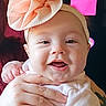 Raven is registered to the contest to win money with this photo: baby, smiling, headband, bow, hands, tattoo, person, indoor, kitchen, fridge, notes, magnet, clothing, cute, infant, portrait, happy, holding, child, family