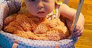 Raven joined the competition — help win amazing prizes! baby, child, infant, baby_jumper, blanket, holding, floor, wood_floor, indoors, curious, looking_up, straps, clothing, person, young_child, cute, home, soft_toy, seated, portrait