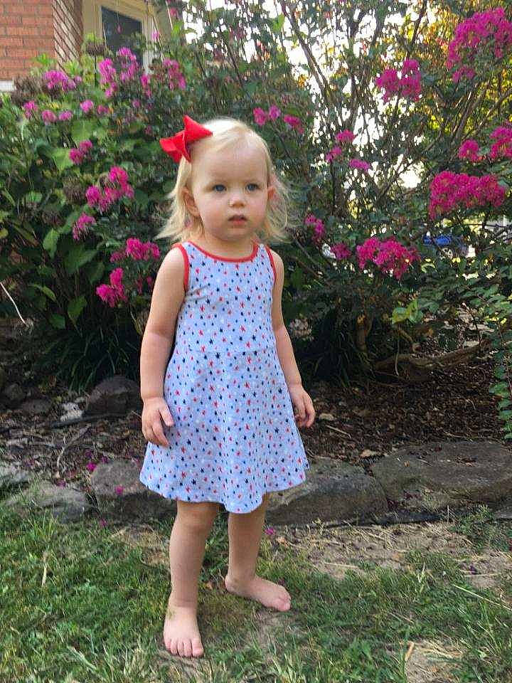 Blakeleigh is registered to the contest to win money with this photo: baby_toddler_clothing, child, child_model, clothing, design, dress, flower, garden, grass, pattern, person, pink, plant, polka_dot, spring, summer, toddler, wildflower, yard