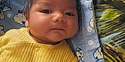 Kieran is registered to the contest to win money with this photo: baby, infant, child, yellow_clothing, blanket, bed, pillow, face, portrait, lying_down, indoors, calm, cute, young_child, head, skin, human, comfort, resting, sleepwear