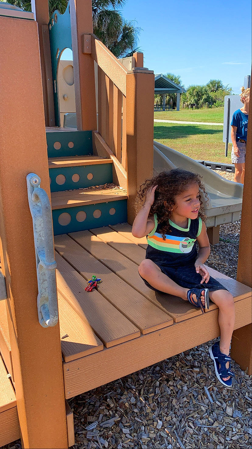 Neiko joined the competition — help win amazing prizes! blue, city, flooring, fun, grass, hardwood, landscape, leisure, outdoor_furniture, person, public_space, recreation, shade, shoe, shorts, sky, sneakers, toddler, tree, wood