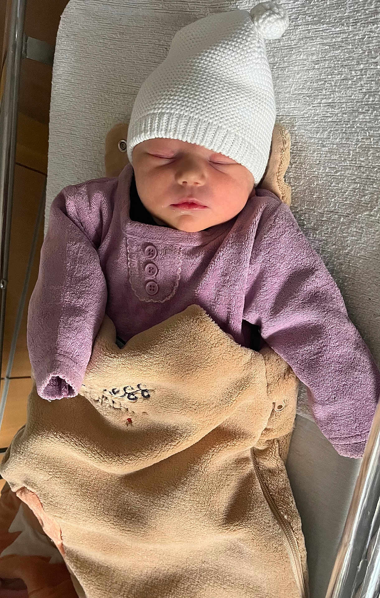 Alicia participe au concours pour gagner de l'argent avec cette photo : baby, sleeping, hat, blanket, purple_clothing, crib, cozy, infant, peaceful, soft_texture, knit_hat, wrapped, resting, indoors, child, newborn, cute, warm, portrait, toddler
