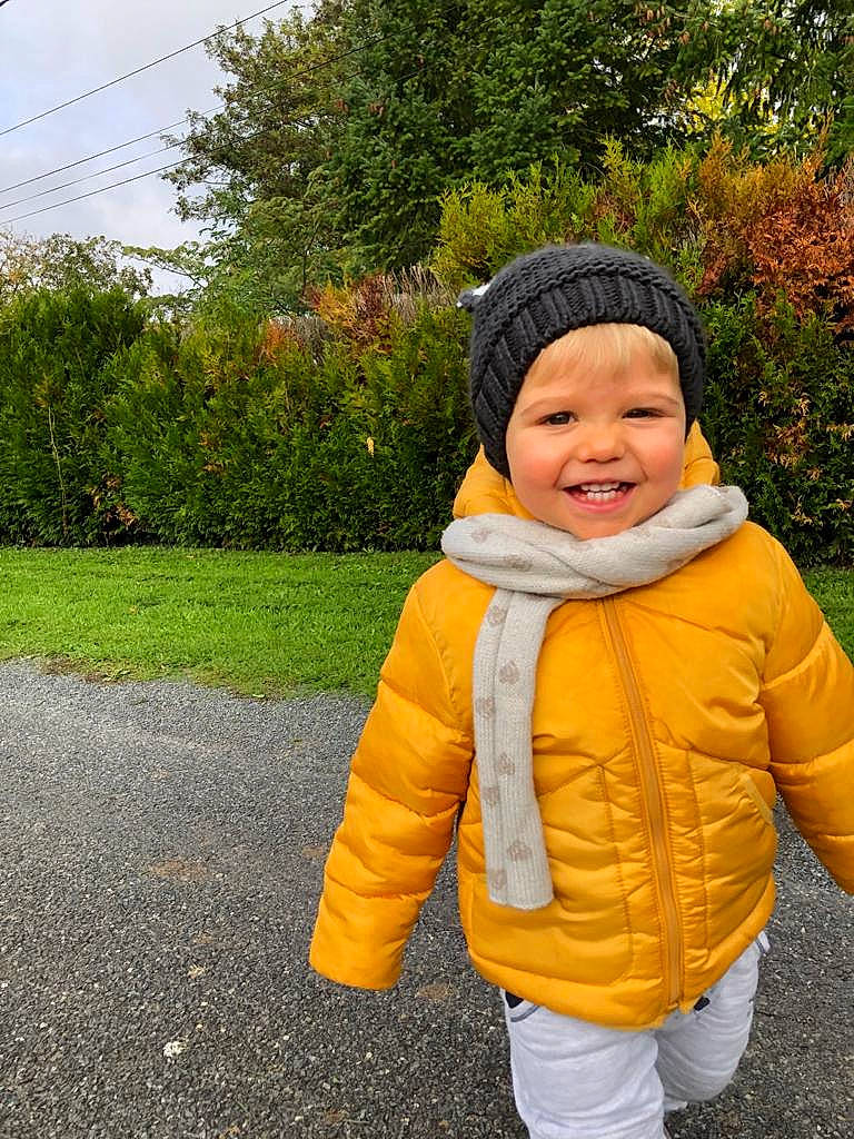 Nils participe au concours pour gagner de l'argent avec cette photo : asphalt, baby_toddler_clothing, child, fun, fur, grass, happy, headwear, hood, jacket, joy, landscape, leisure, people_in_nature, person, plant, road_surface, sky, sleeve, smile
