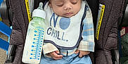 Evin Collin joined the competition — help win amazing prizes! baby, car_seat, bottle, sleeping, hat, bib, milk, clothing, infant, footwear, socks, blue_pants, plaid_shirt, indoor, child, cute, peaceful, resting, toddler, baby_bottle