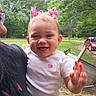 Kyndall joined the competition — help win amazing prizes! baby, child, smiling, happy, pink_bows, hair, hand, wave, outdoor, greenery, grass, trees, car, person, closeup, cute, white_shirt, heart, portrait, daylight