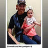 baby, bow, cap, caption, casual, child, clothing, date, family, holding, indoor, man, people, photo, portrait, screen, sitting, skirt, text_overlay, wall