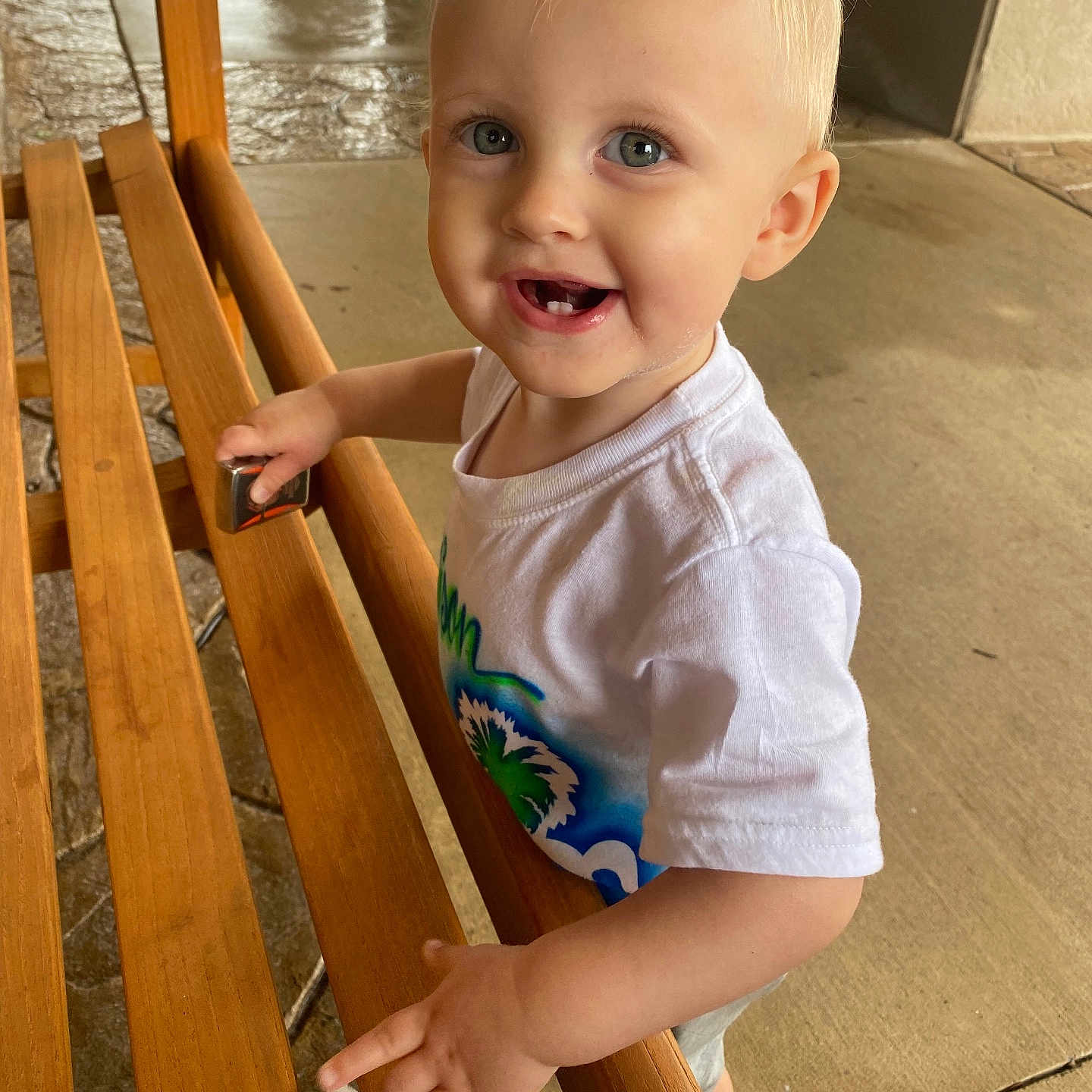 Addison is registered to the contest to win money with this photo: baby, bench, bodypart, city, clothing, face, finger, furniture, hand, hardwood, head, pants, person, photography, plywood, portrait, road, sitting, t_shirt, wood