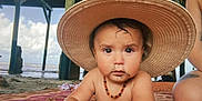 Fox is registered to the contest to win money with this photo: toddler, child, hat, beach, pier, sand, necklace, blanket, sunhat, outdoor, water, ocean, sky, clouds, person, summer, vacation, cute, portrait, curious