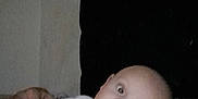 Archie is registered to the contest to win money with this photo: baby, infant, child, blanket, white_clothing, face, eyes, hand, skin, person, lying_down, indoors, soft_toy, curious, expression, head, pale_skin, blue_blanket, casual, closeup