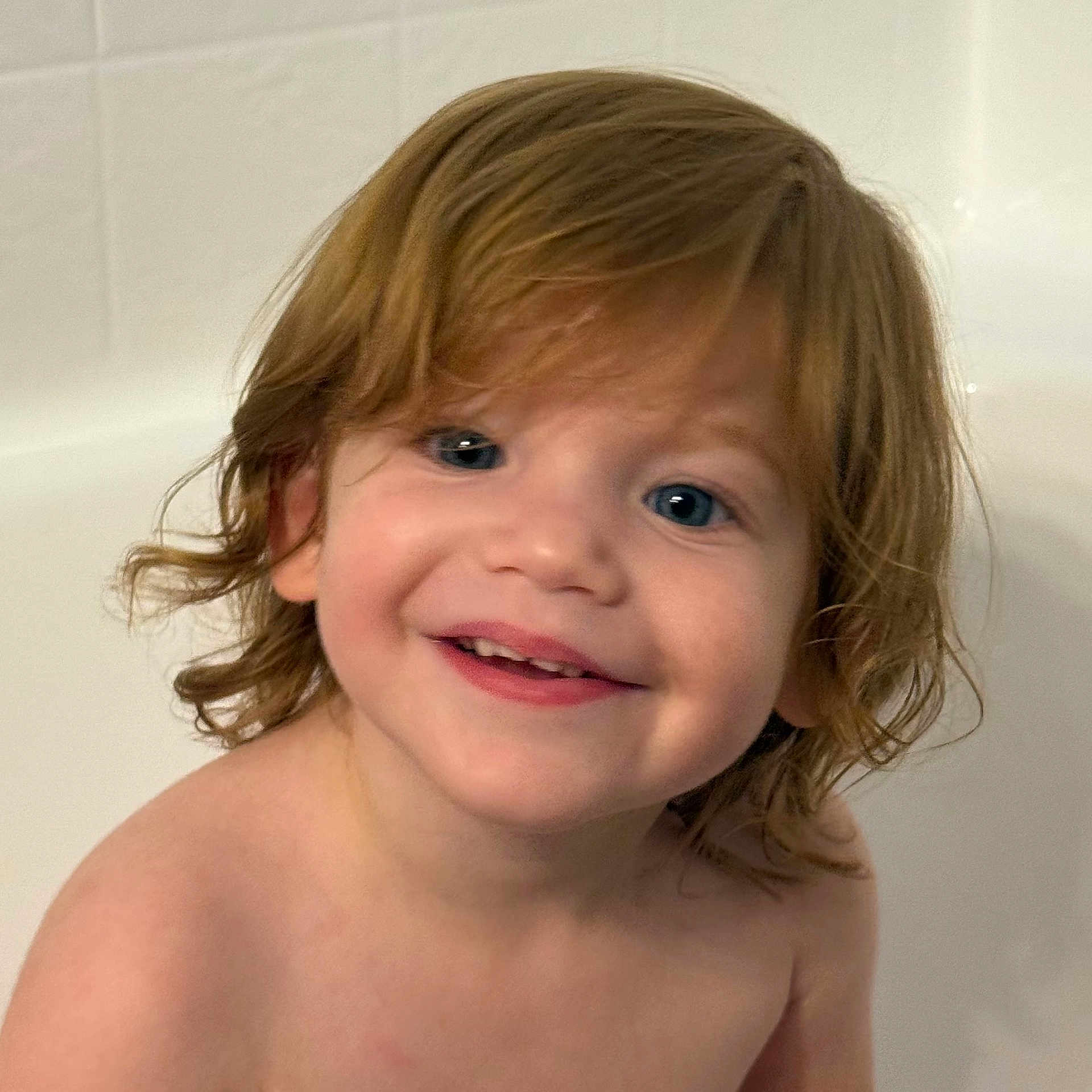 Elia is registered to the contest to win money with this photo: toddler, child, smile, face, blue_eyes, hair, bathroom, skin, shoulders, portrait, happy, cute, indoors, person, young_child, closeup, head, bare_shoulders, childhood, expression