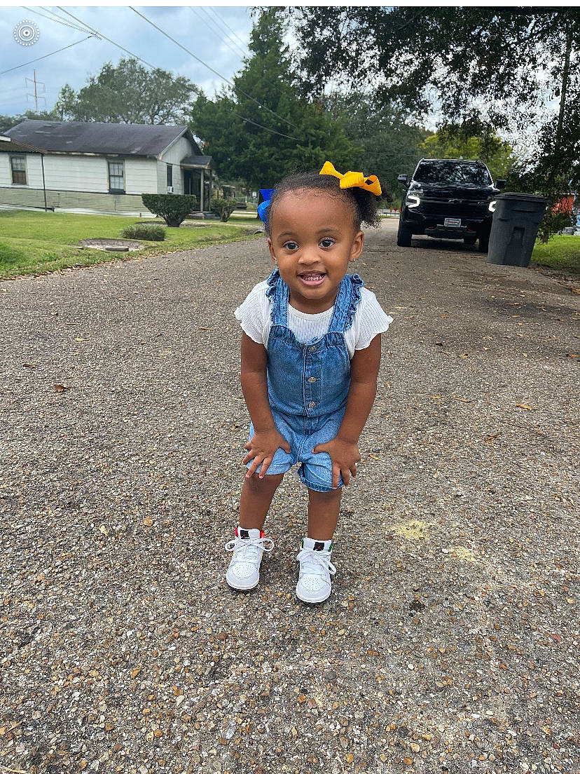 Makana is registered to the contest to win money with this photo: asphalt, automotive_tire, baby_toddler_clothing, car, grass, happy, hat, joy, landscape, leaf, leisure, person, plant, road_surface, sky, smile, t_shirt, tire, toddler, tree