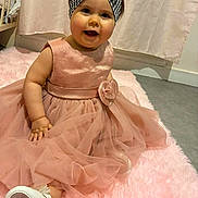 Maelyne a rejoint le concours — aidez-le/la à gagner de superbes lots ! apparel, baby, carpet, child, cute, dress, fabric, floor, flower, footwear, happy, headband, indoor, person, pink, shoe, sitting, smile, soft, toddler