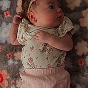 Amelia is registered to the contest to win money with this photo: baby, infant, pink_bow, headband, floral_blanket, cute, sleepwear, pastel_colors, lying_down, newborn, soft_texture, patterned_clothing, mickey_mouse, minnie_mouse, child, portrait, indoors, hand, face, cozy