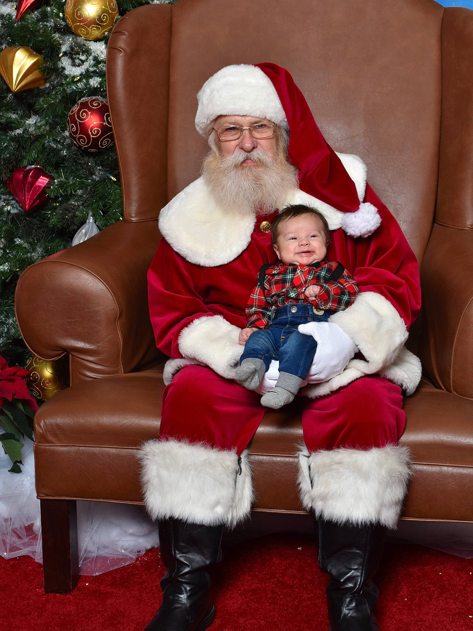 Steve is registered to the contest to win money with this photo: beard, christmas, christmas_tree, clothing, comfort, facial_expression, happy, hat, head, headwear, human_body, lap, leg, organ, person, photograph, red, santa_claus, sleeve, smile