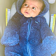 Samp is registered to the contest to win money with this photo: baby, child, infant, blue_outfit, hooded_jacket, car_seat, warning_label, curious, wide_eyes, cozy, cute, warm_clothing, indoor, portrait, soft_texture, young_child, looking_away, seated, clothing_zipper, adorable