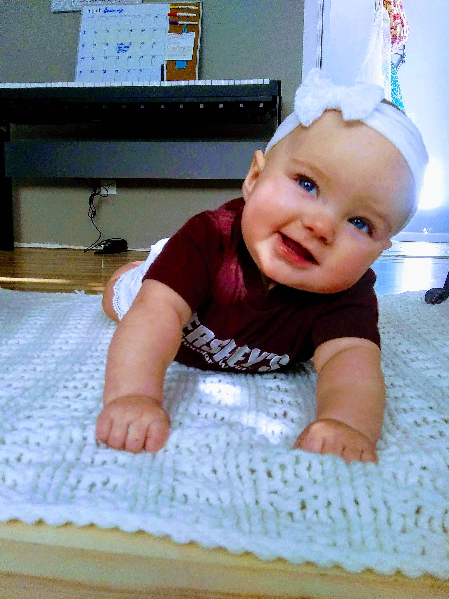 Izzy joined the competition — help win amazing prizes! baby, baby_products, baby_toddler_clothing, cheek, child, floor, happy, head, headgear, headwear, person, product, skin, smile, textile, toddler, tummy_time