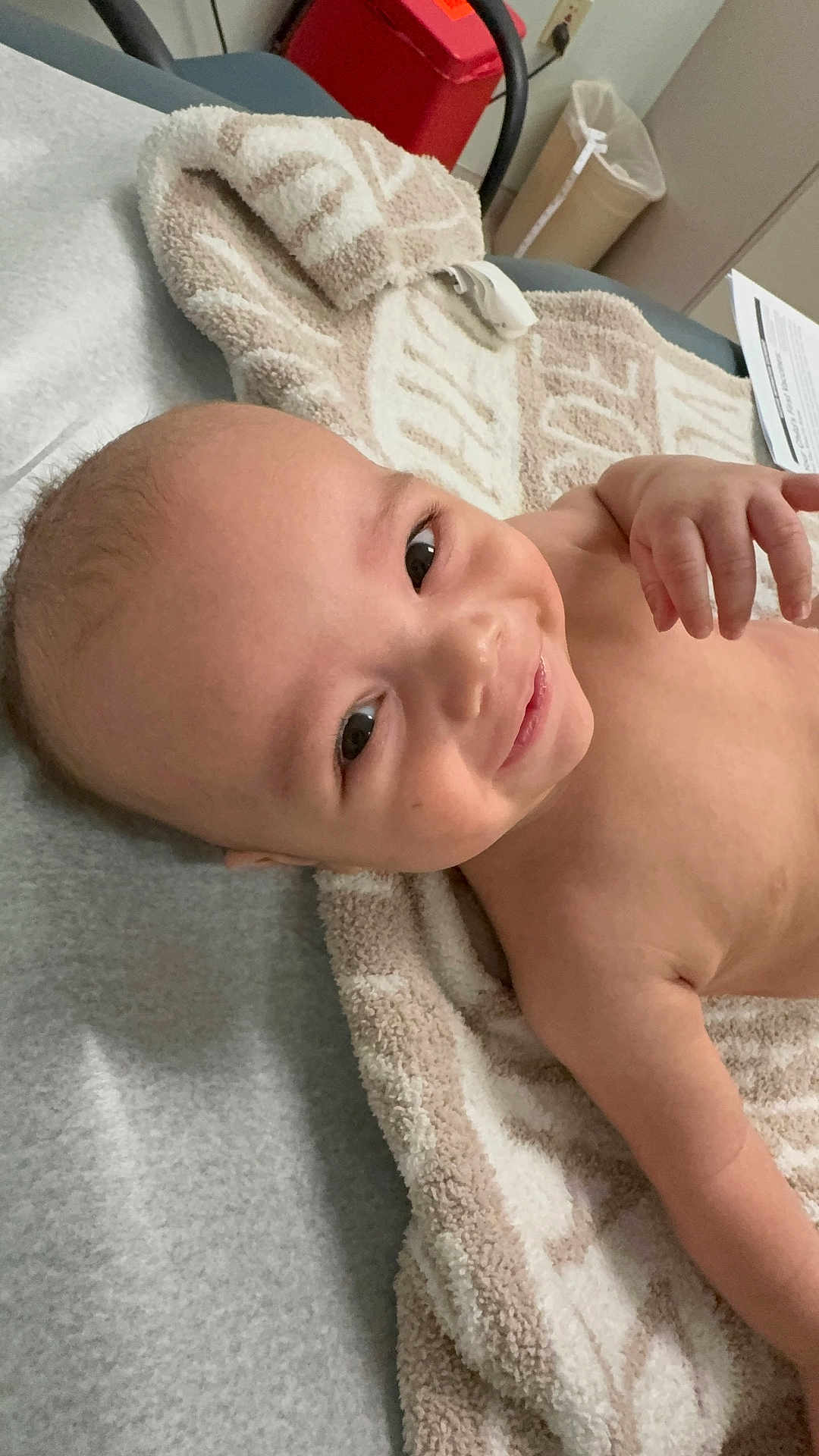 Ziven is registered to the contest to win money with this photo: baby, blanket, cheerful, child, cute, expression, face, furniture, hand, happy, head, indoor, infant, lying_down, person, room, skin, smiling, towel, young