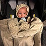Ziven joined the competition — help win amazing prizes! baby, blanket, bottle, car_seat, clothing, cozy, cute, face, hood, indoors, infant, milk, person, portrait, sitting, surprised, toddler, warm, wearing, young_child