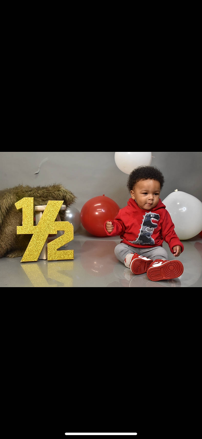 Fortune is registered to the contest to win money with this photo: advertising, baby, baby_toddler_clothing, carmine, flash_photography, flooring, font, fun, happy, logo, person, personal_protective_equipment, play, recreation, sitting, sleeve, t_shirt, toddler, toy, wood