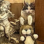 cat, plush_toy, bunny, stuffed_animal, door, statue, cherub, indoor, wood, fur, animal, decor, toy, curiosity, peek, face, ears, feline, cozy, whimsical