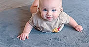 Ethan is registered to the contest to win money with this photo: baby, beige_shirt, blue_eyes, carpet, child, clothing, crawling, cute, floor, hand, head, home, indoor, infant, person, portrait, skin, smiling, toddler, winnie_the_pooh