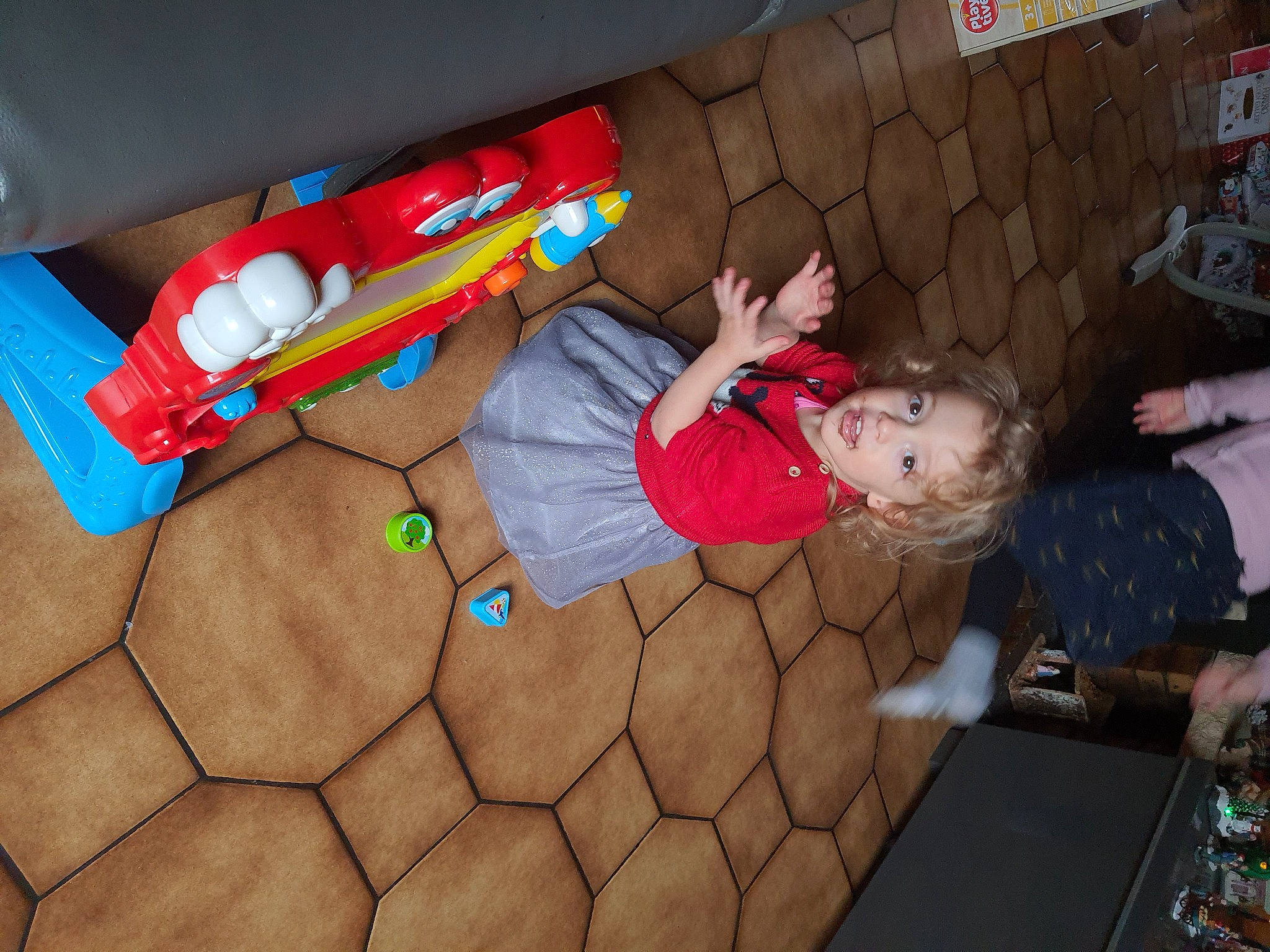 Laïana participe au concours pour gagner de l'argent avec cette photo : baby, baby_products, baby_toddler_clothing, baby_toys, child, comfort, flooring, fun, hardwood, human_leg, leisure, person, plastic, play, room, sock, t_shirt, thigh, toddler, toy