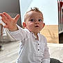 Ange a rejoint le concours — aidez-le/la à gagner de superbes lots ! baby, blue_eyes, casual_clothing, child, curious, cute, expression, green_pants, hand_reaching, home, indoor, modern_interior, natural_light, person, portrait, sitting, small_child, toddler, white_shirt, wooden_floor