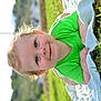 baby, child, smiling, blue_eyes, curly_hair, green_shirt, blanket, grass, outdoor, sunny, nature, portrait, happy, infant, face, crawling, closeup, daylight, cute, toddler