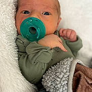 Cedrick joined the competition — help win amazing prizes! baby, newborn, pacifier, blanket, clothing, face, hand, sleepwear, infant, closeup, portrait, soft_texture, comfort, cute, child, cuddle, warm, expression, skin, lying_down