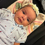 Charlotte joined the competition — help win amazing prizes! baby, infant, headband, flower, blanket, striped_clothing, patterned_clothing, pastel_colors, rainbow_pattern, soft_texture, face, eyes, cute, lying_down, indoors, closeup, portrait, child, comfort, adorable