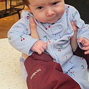 Aurora joined the competition — help win amazing prizes! baby, child, person, hair, mohawk, blue_outfit, cherry_pattern, hand, jacket, table, indoor, waiting_room, expression, skeptical, face, holding, sitting, furniture, timestamp, text_overlay
