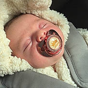 Alliyah a rejoint le concours — aidez-le/la à gagner de superbes lots ! baby, sleeping, pacifier, crown, fluffy_clothing, car_seat, harness, infant, closeup, face, soft_texture, cozy, child, resting, cute, indoors, pink_skin, head, comfort, peaceful