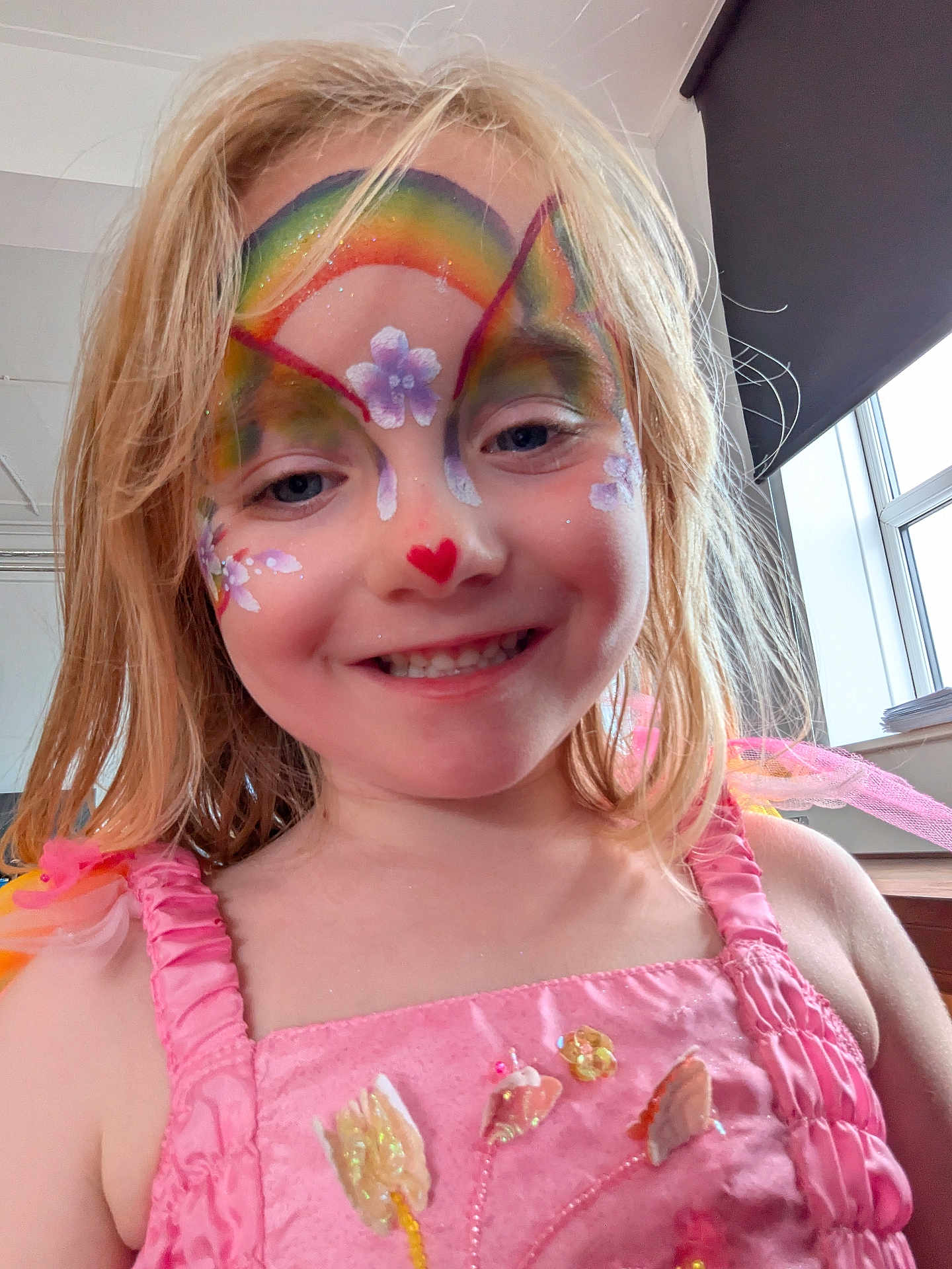 Grace joined the competition — help win amazing prizes! child, face_paint, rainbow, flower, heart, pink_dress, smile, blonde_hair, indoor, window, natural_light, decorations, sparkle, portrait, cute, happy, young, person, closeup, colorful