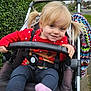 Grace joined the competition — help win amazing prizes! child, toddler, stroller, outdoor, smiling, blonde_hair, pigtails, red_sweater, leggings, pink_socks, seatbelt, cushion, hand, face, nature, hedge, sidewalk, blanket, colorful, daytime