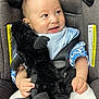 Su-Jin is registered to the contest to win money with this photo: baby, black, blue, car_seat, child, closeup, clothing, cute, face, glitter, hands, happy, indoor, infant, seatbelt, sitting, smile, stuffed_animal, toy, white