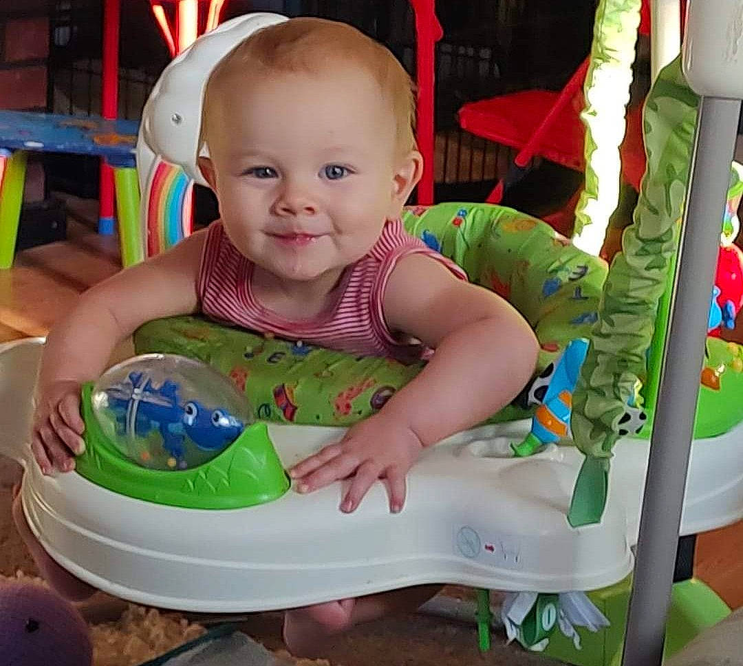 Bronson is registered to the contest to win money with this photo: baby, baby_products, baby_toddler_clothing, baby_toys, chair, child, event, fun, happy, joy, leisure, person, pink, plastic, play, sitting, smile, sock, toddler