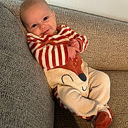 Louise a rejoint le concours — aidez-le/la à gagner de superbes lots ! baby, child, smiling, couch, onesie, striped_clothing, fox_design, comfortable, indoor, portrait, happy, infant, seated, cozy, cute, person, fabric, soft_toys, home, relaxed