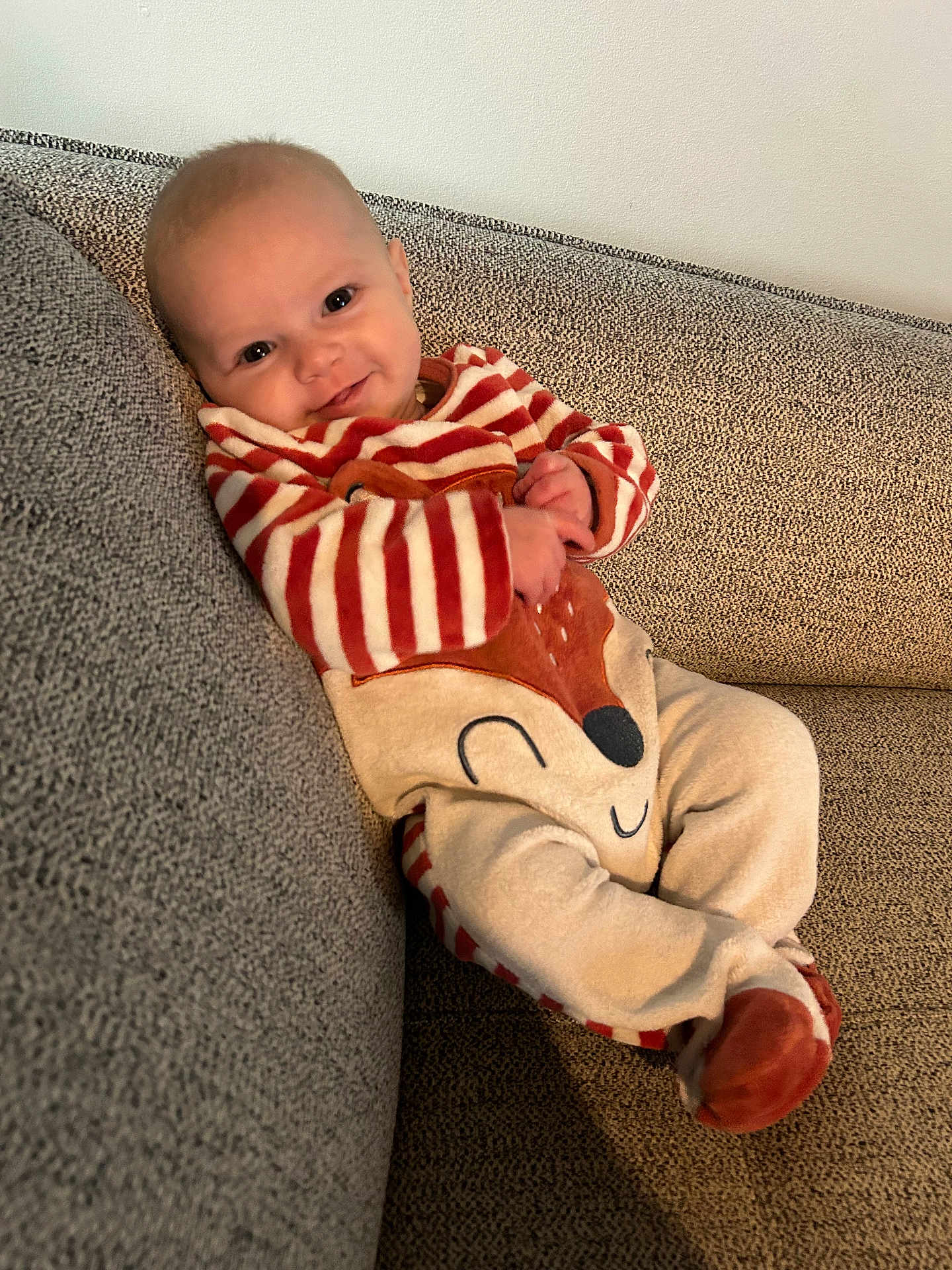 Louise a rejoint le concours — aidez-le/la à gagner de superbes lots ! baby, child, smiling, couch, onesie, striped_clothing, fox_design, comfortable, indoor, portrait, happy, infant, seated, cozy, cute, person, fabric, soft_toys, home, relaxed