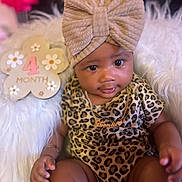 Honestii joined the competition — help win amazing prizes! baby, infant, child, leopard_print, headband, bow, necklace, gold, nameplate, fluffy_chair, white_fur, milestone_sign, 4_months, cute, portrait, indoors, smiling, person, sitting, closeup