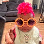 Honestii joined the competition — help win amazing prizes! baby, child, sunglasses, headband, flower, bib, hand, indoor, living_room, couch, floor, person, cute, accessory, portrait, clothing, infant, holding, funny_glasses, homedecor
