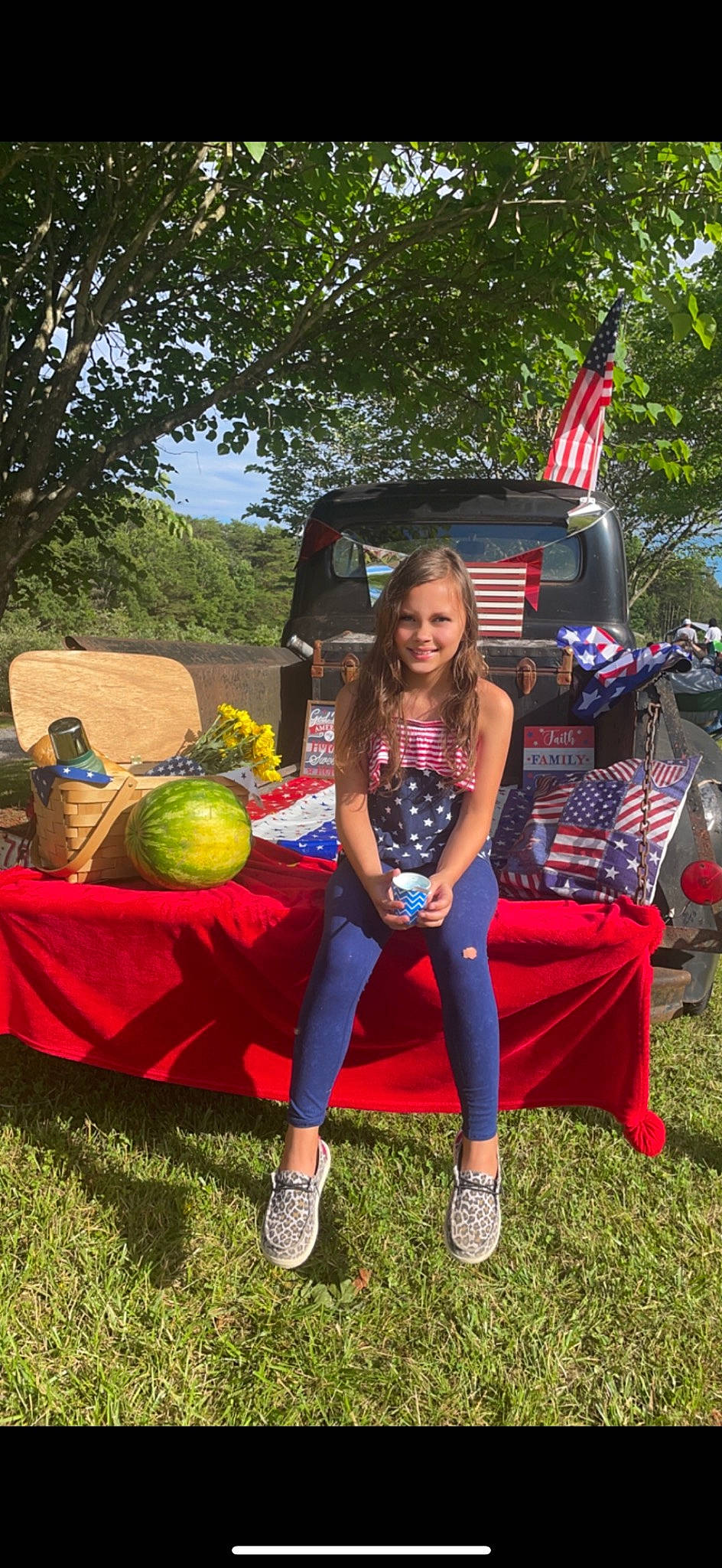 Emma Kate is registered to the contest to win money with this photo: cucurbita, event, flag, flag_of_the_united_states, fruit, fun, grass, happy, joy, leisure, motor_vehicle, natural_foods, person, plant, pumpkin, recreation, sandal, shorts, smile, summer