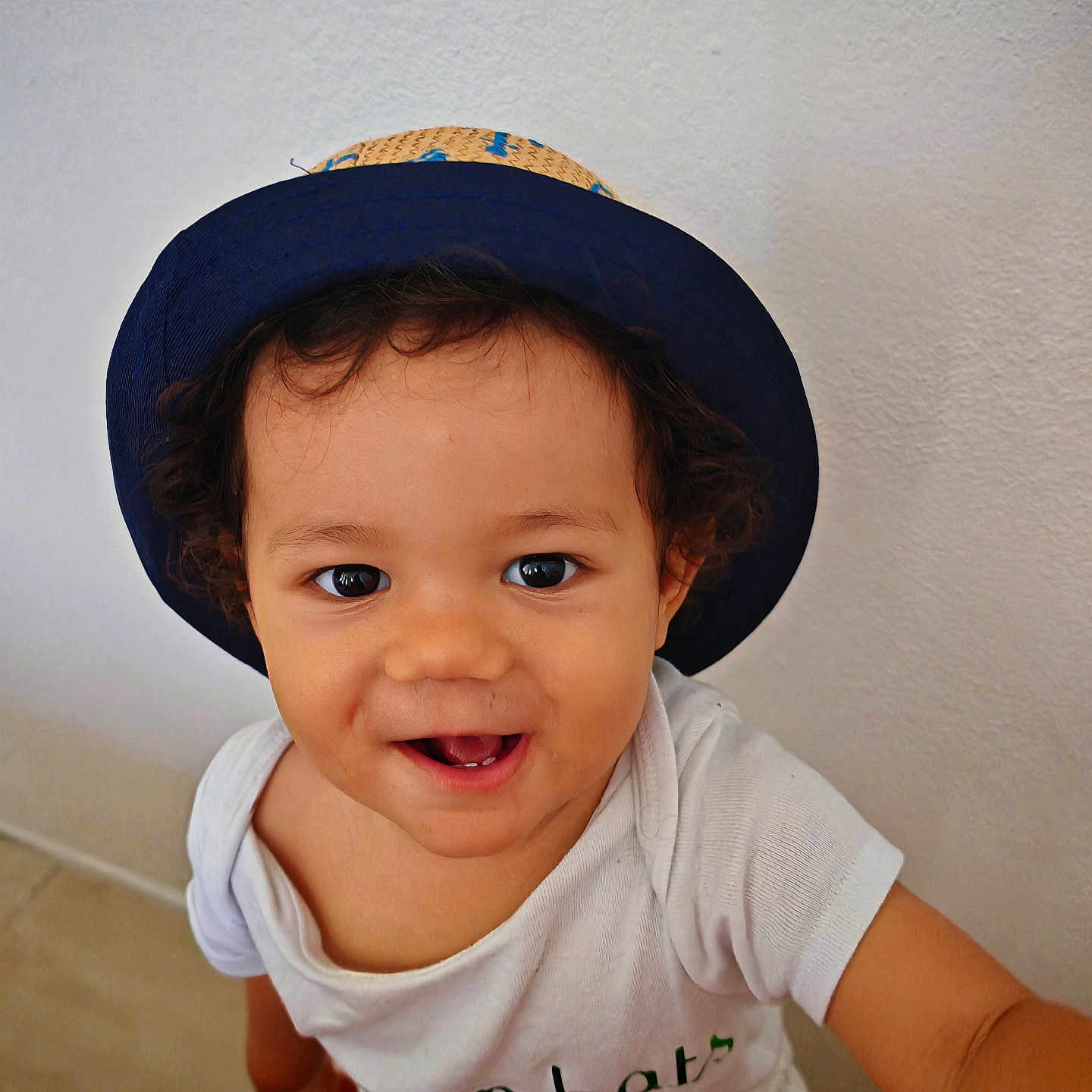 Azaël a rejoint le concours — aidez-le/la à gagner de superbes lots ! baby, casual, child, curly_hair, cute, expression, eyes, face, happy, hat, indoors, joyful, looking_up, person, portrait, sitting, skin, smiling, toddler, white_shirt